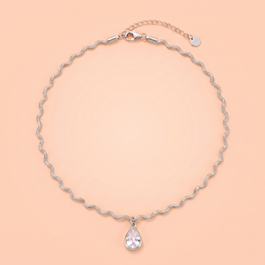 Onda Choker in silver laid flat on a peach background