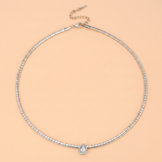 Aura Choker in silver laid flat on a peach background