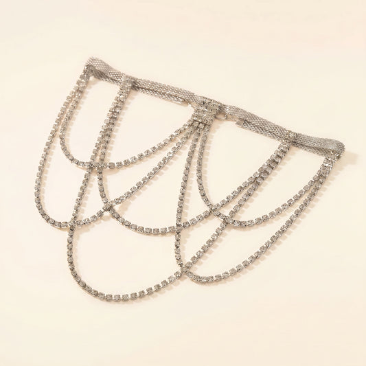 A silver-toned rhinestone chain choker with multiple draped loops, displayed on a plain light beige background.