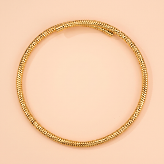 Spira Choker Gold flat lay on peach