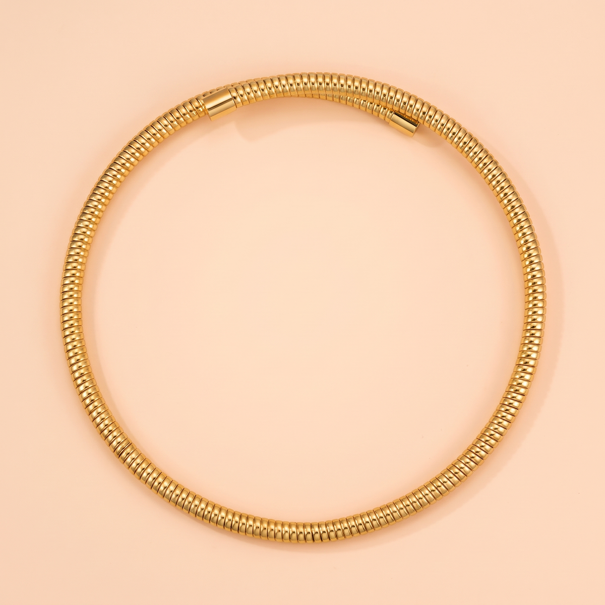 Spira Choker Gold flat lay on peach