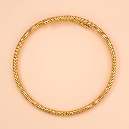 Spira Choker Gold flat lay on peach