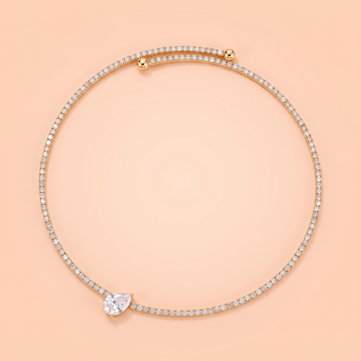 Giro Choker in gold laid flat on a peach background