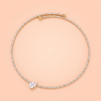 Giro Choker in gold laid flat on a peach background