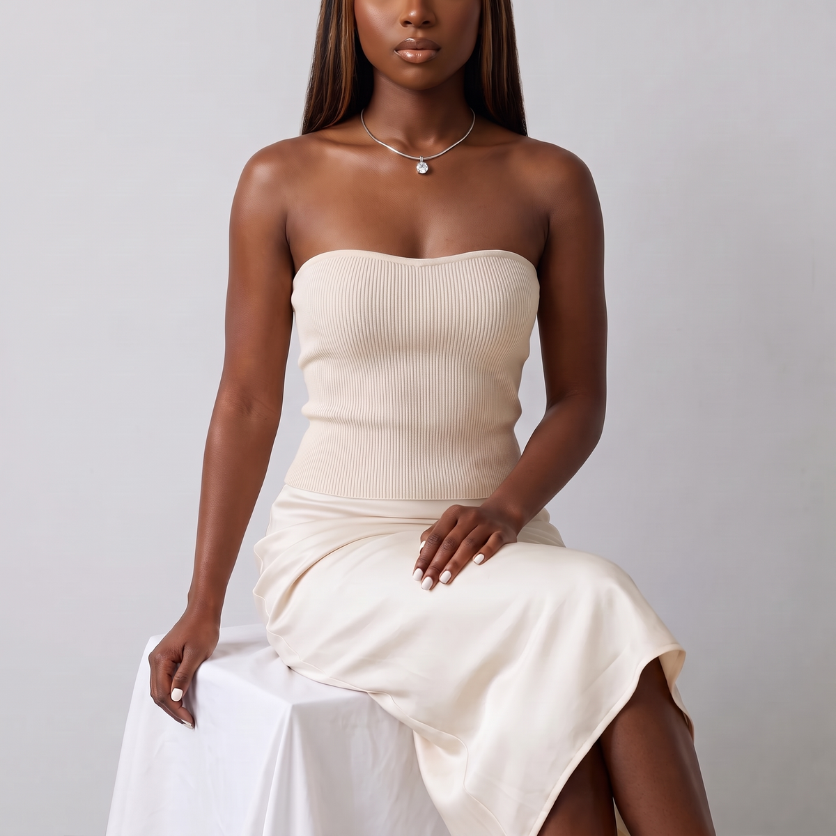 Model seated in a cream knit top wearing the Unica Choker in silver