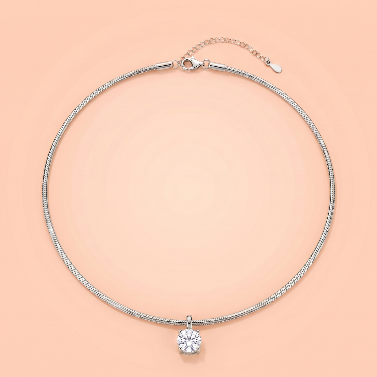 Unica Choker in silver laid flat on a peach background