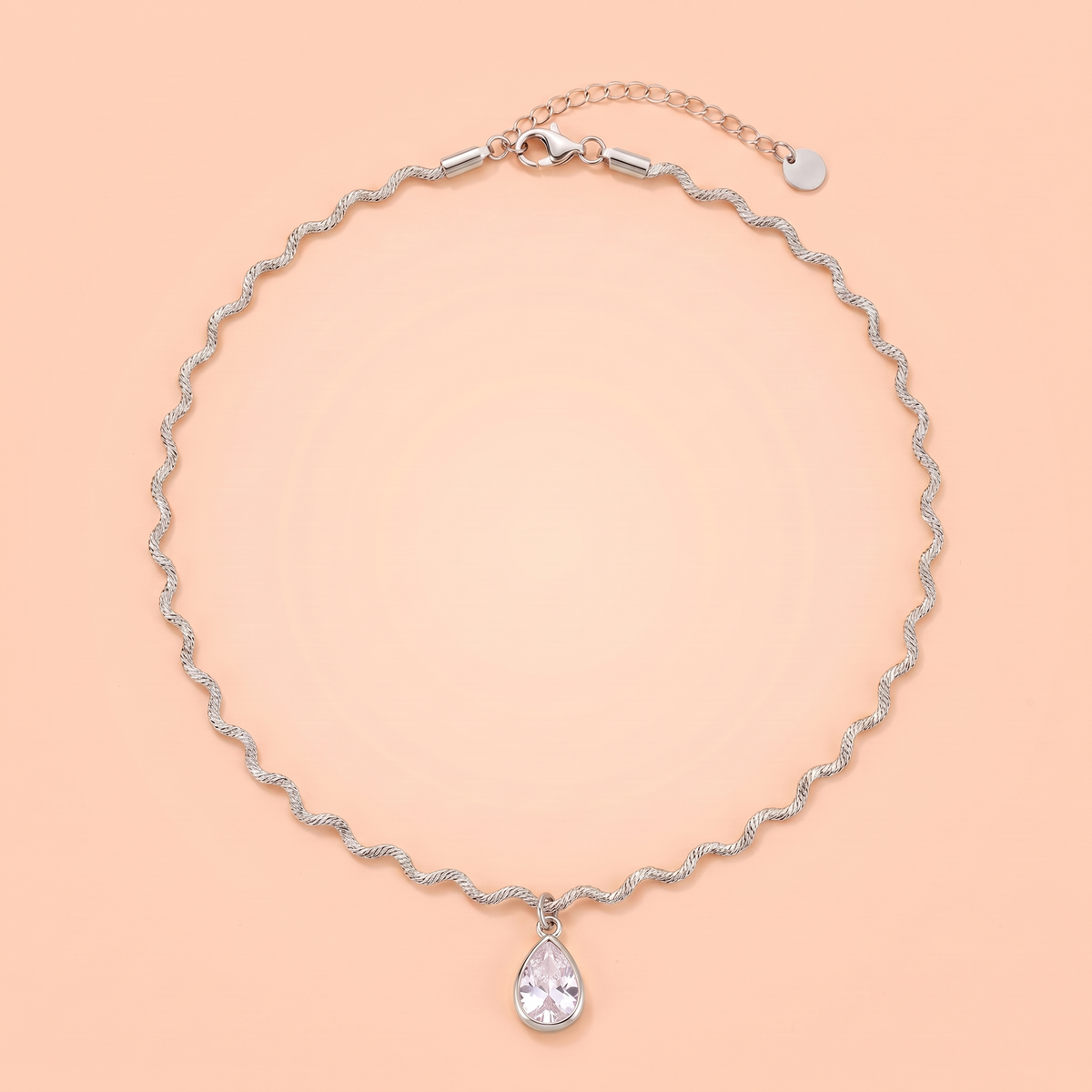 Onda Choker in silver laid flat on a peach background
