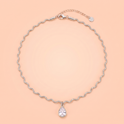 Onda Choker in silver laid flat on a peach background
