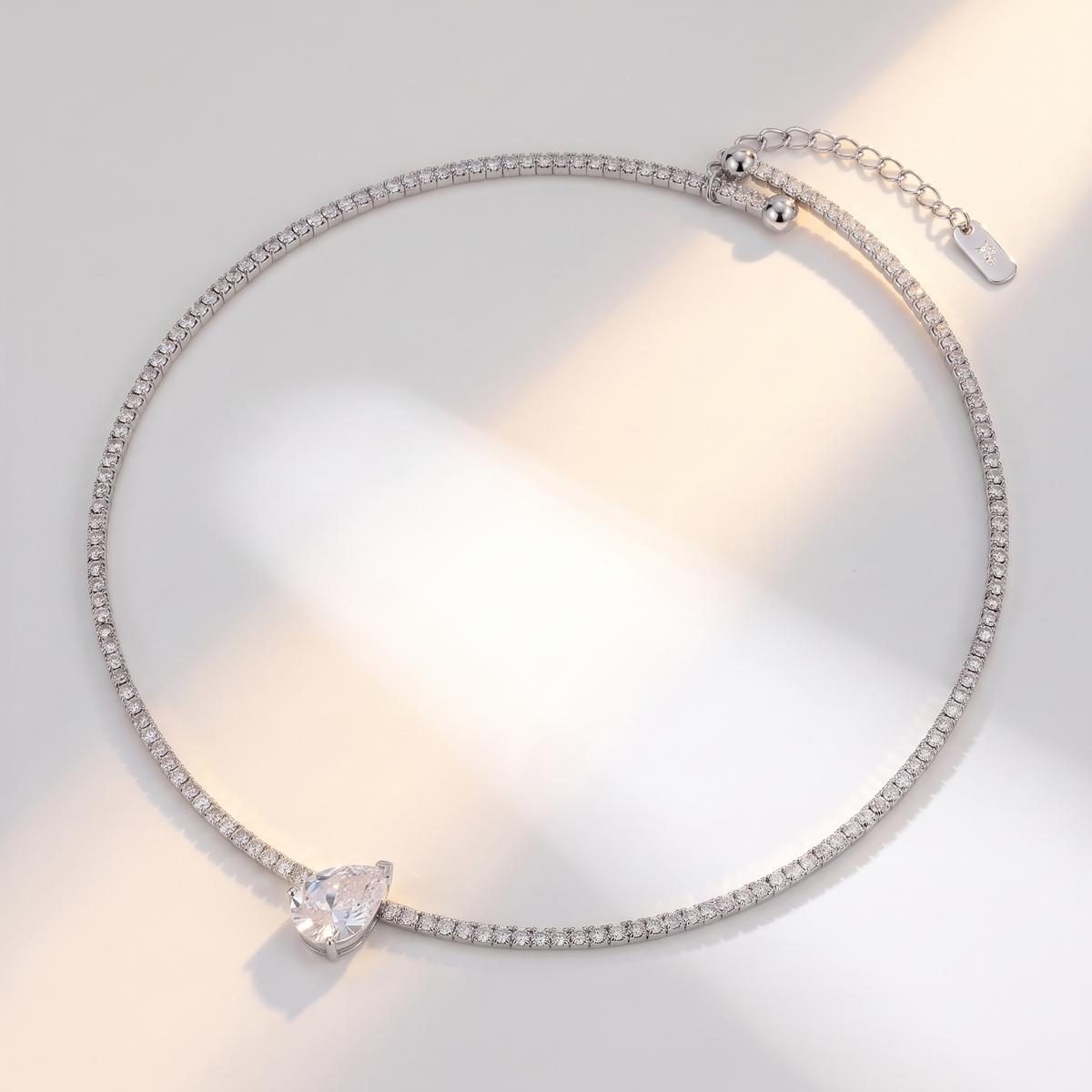 Giro Choker in silver on a white surface in soft sunlight