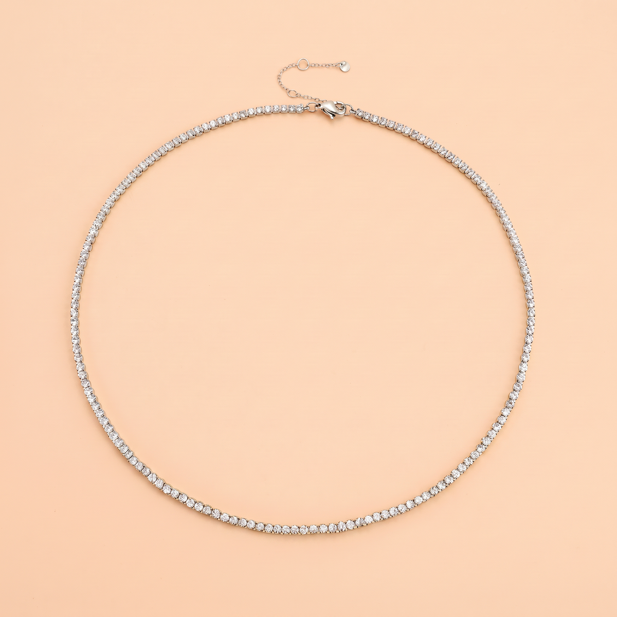 Filo Choker in silver laid flat on a peach background