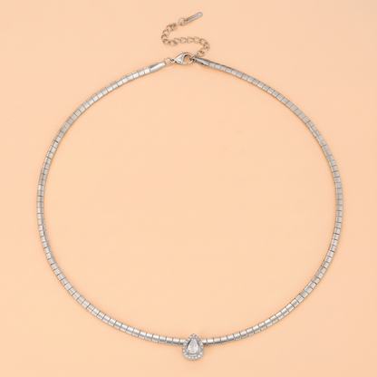 Aura Choker in silver laid flat on a peach background