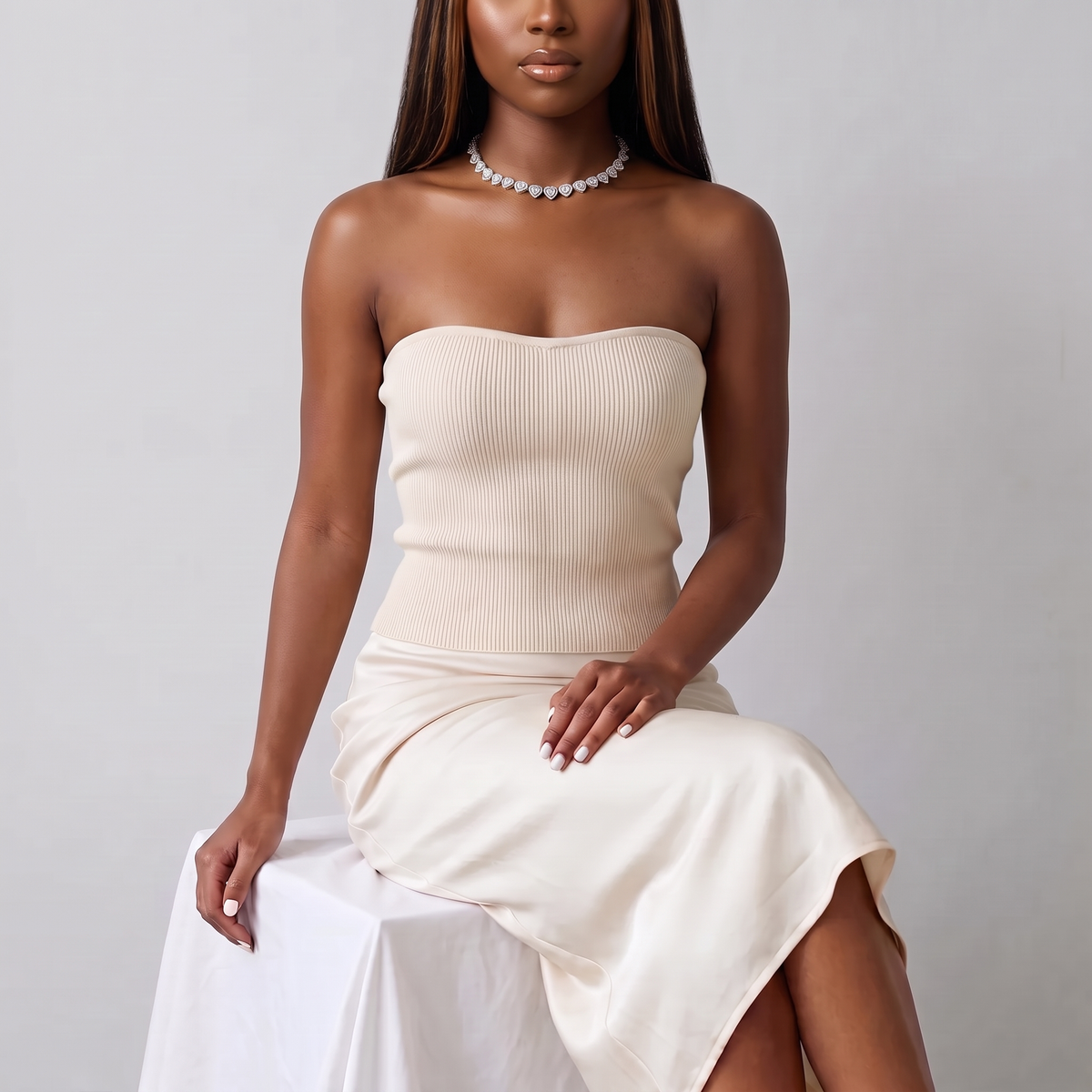 Model seated in a cream knit top wearing the Amore Choker in silver